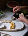 Person preparing food on a kitchen counter with various ingredients and utensils.