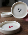 Three ceramic dishes with heart designs on a wooden surface