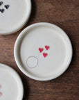 Three ceramic plates with decorative elements on a wooden surface