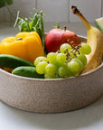 Fruit and vegetables in a bowl on a kitchen counter