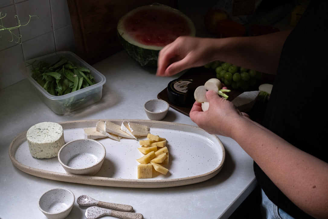 Person preparing food on a kitchen counter with various ingredients and utensils.